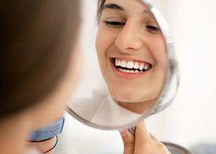 Patient looking at teeth in mirror