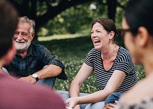 Group of friends laughing in park outside