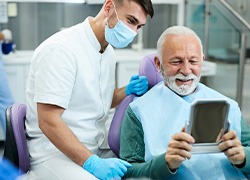 Patient looking at reflection in mirror with dentist