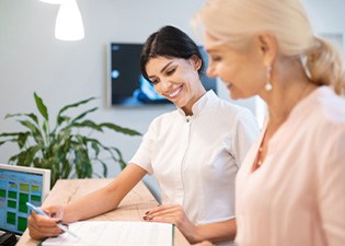Smiling dental assistant showing patient forms