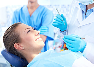 Woman in dental chair smiling at dentist