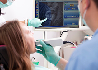 Female patient and dentist examine intraoral photos