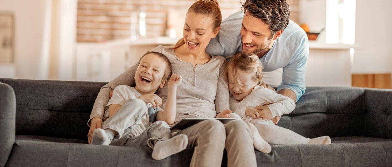 Laughing family of four on couch