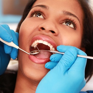 dentist inspecting patient’s teeth