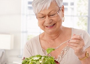 Woman with dentures eating a salad