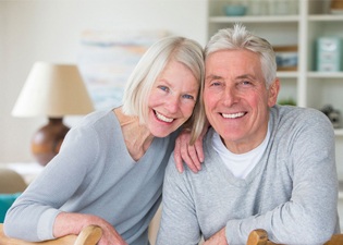 happy elderly couple wearing matching gray sweaters