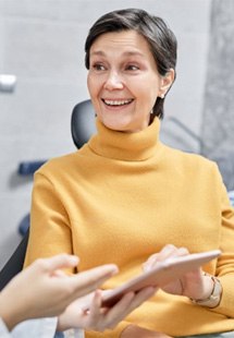 a patient smiling after replacing her missing teeth