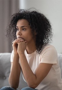 a woman sitting and looking worried