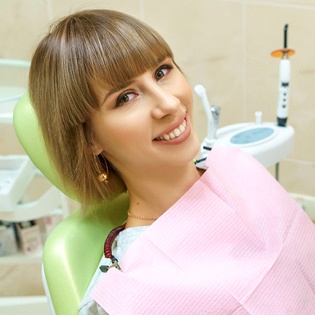 Happy female patient relaxing in dental treatment chair