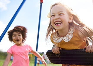 Two young girls smiling at playground