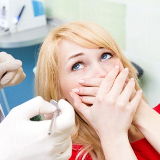 Woman afraid of the dentist in Marlton covering her mouth