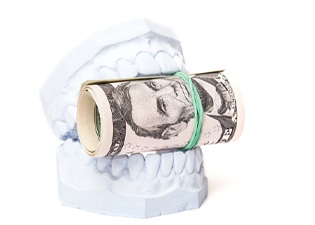 A mouth mold that is holding a roll of money between its teeth in Marlton
