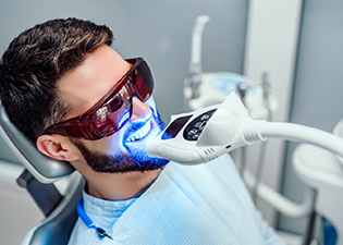 A male patient receiving teeth whitening