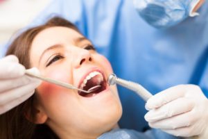 woman having teeth cleaned by hygienist