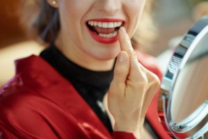 a woman pointing to her tooth that was fixed with dental bonding